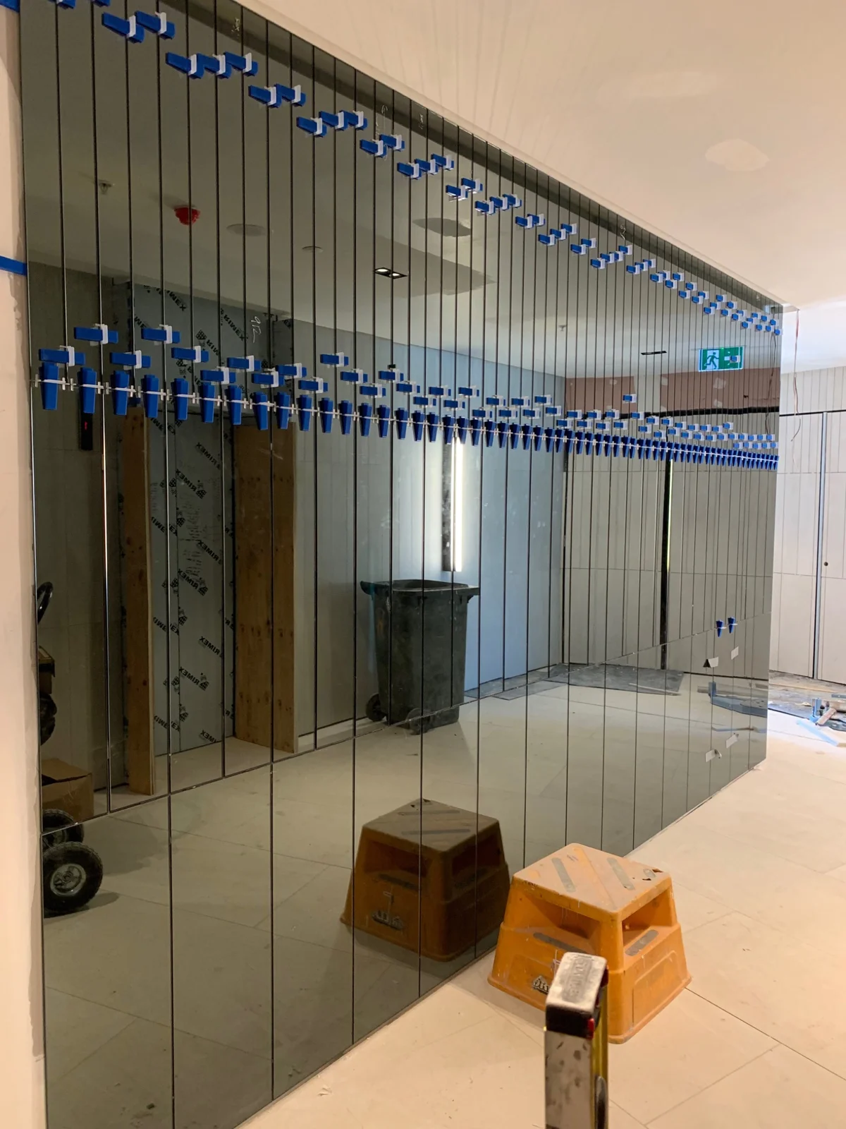Mirrored wall panel installation in progress