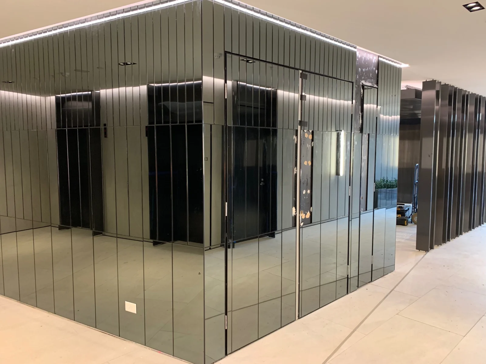 Vertical mirrored glass panels around an interior feature