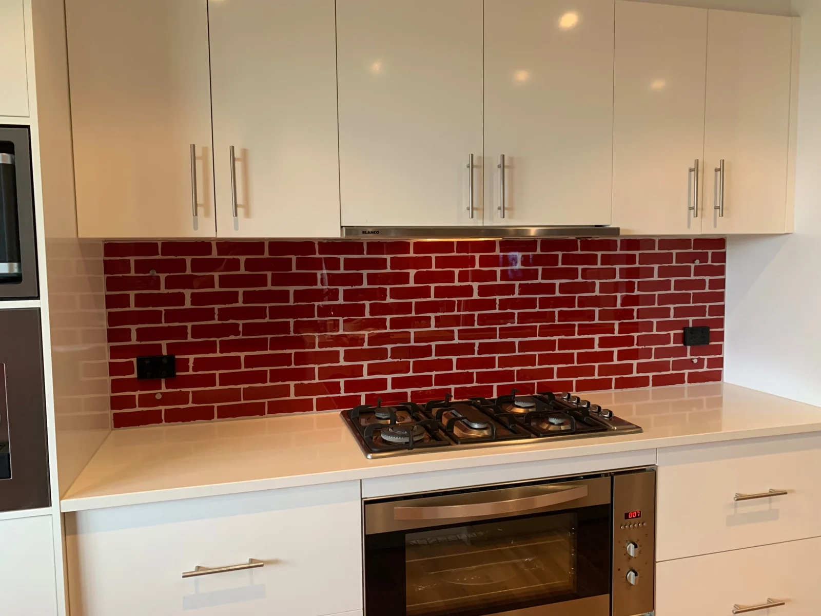 Red brick-effect artwork printed on a glass splashback