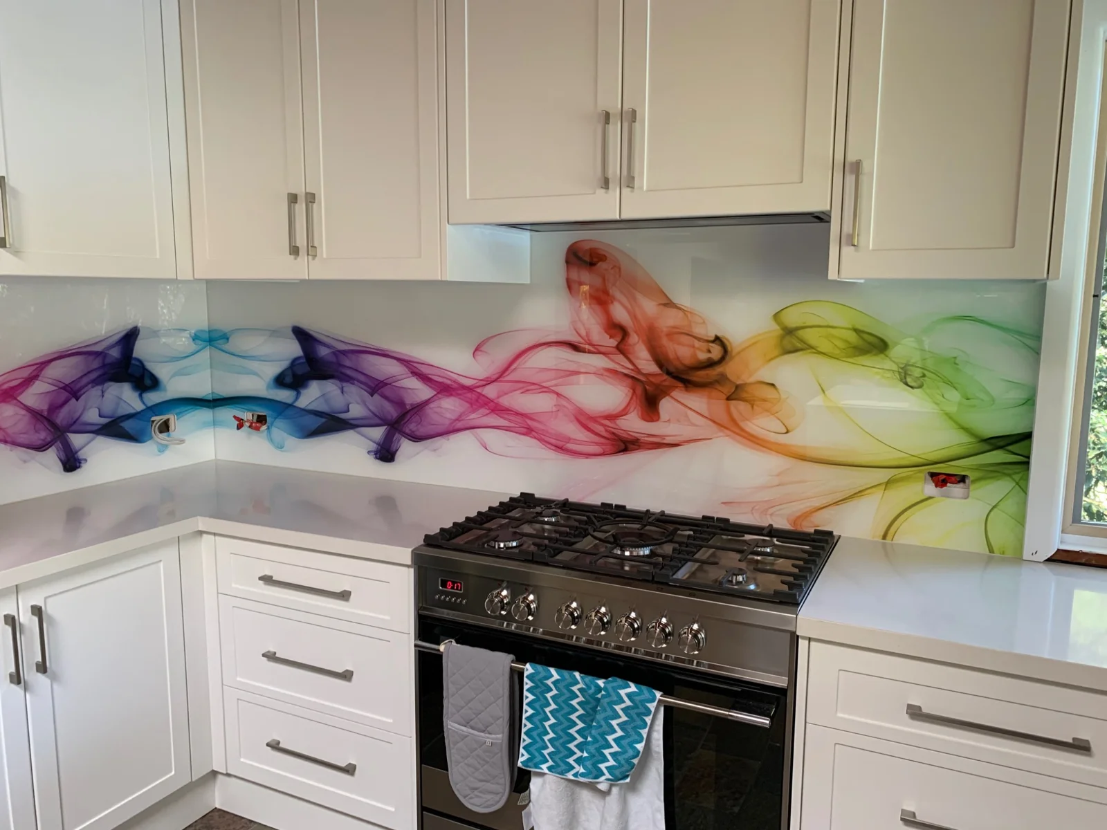 Colourful abstract artwork across a kitchen glass splashback