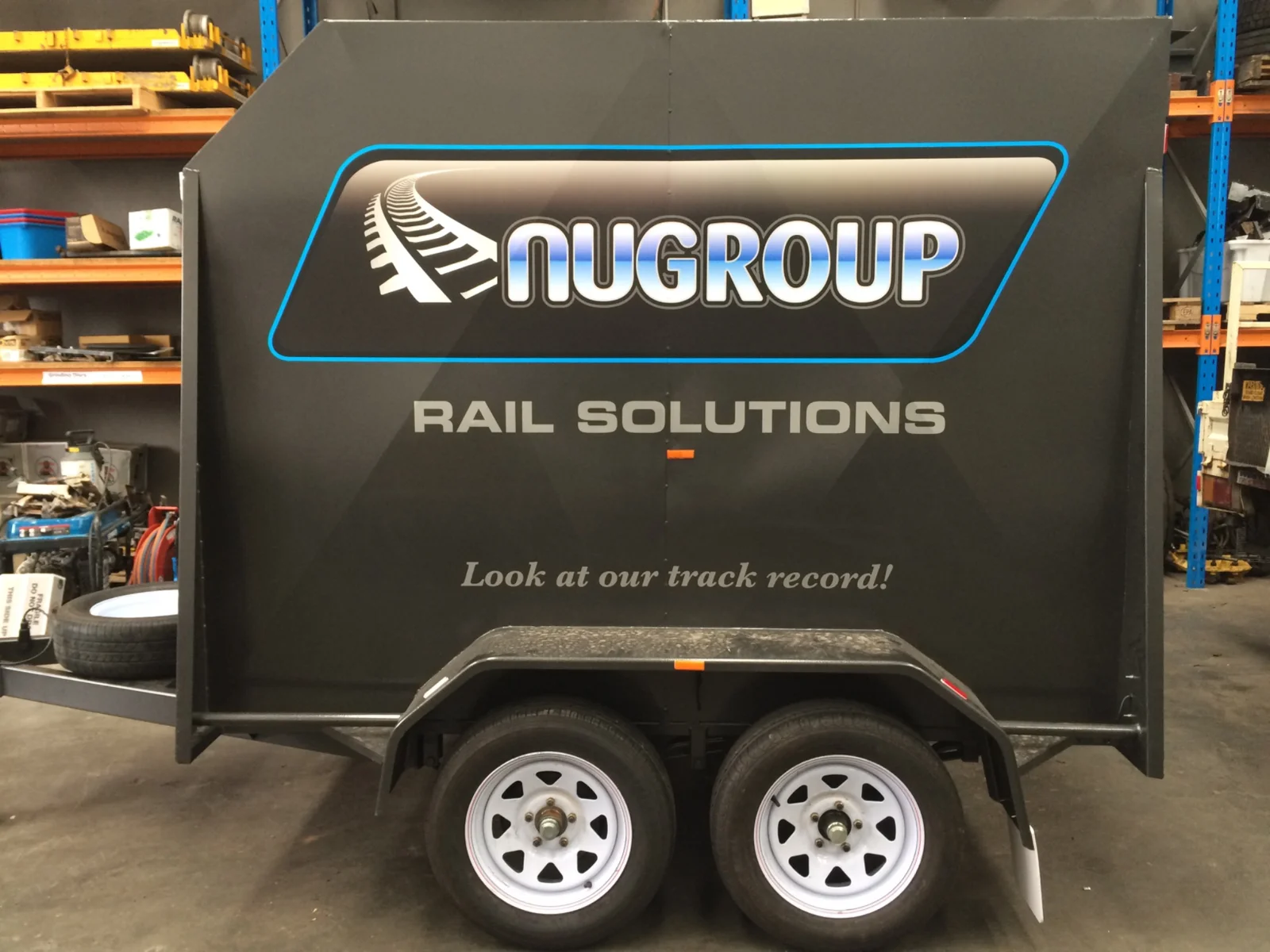 NUGROUP Rail Solutions graphics on a black trailer