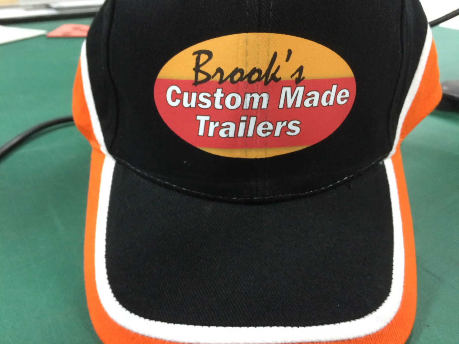 Black and orange cap with Brooks Custom Made Trailers branding