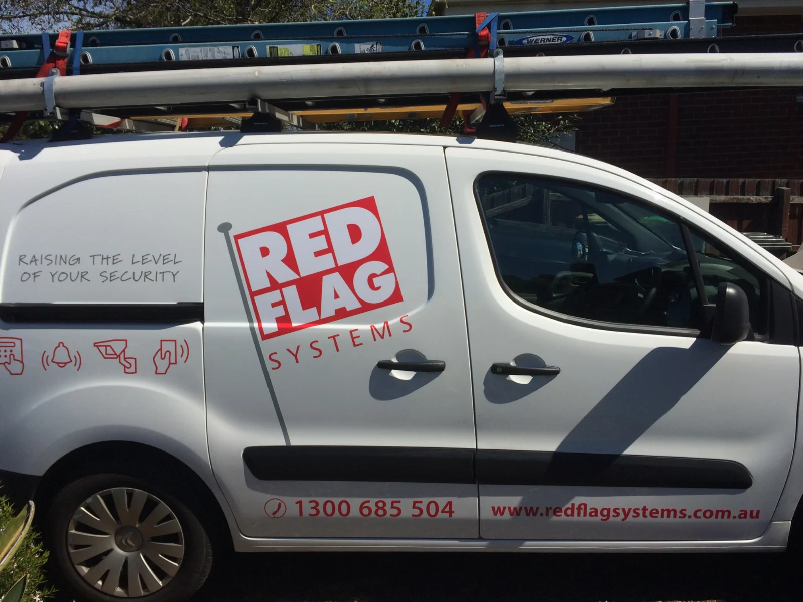 Branded Red Flag Systems work van side view