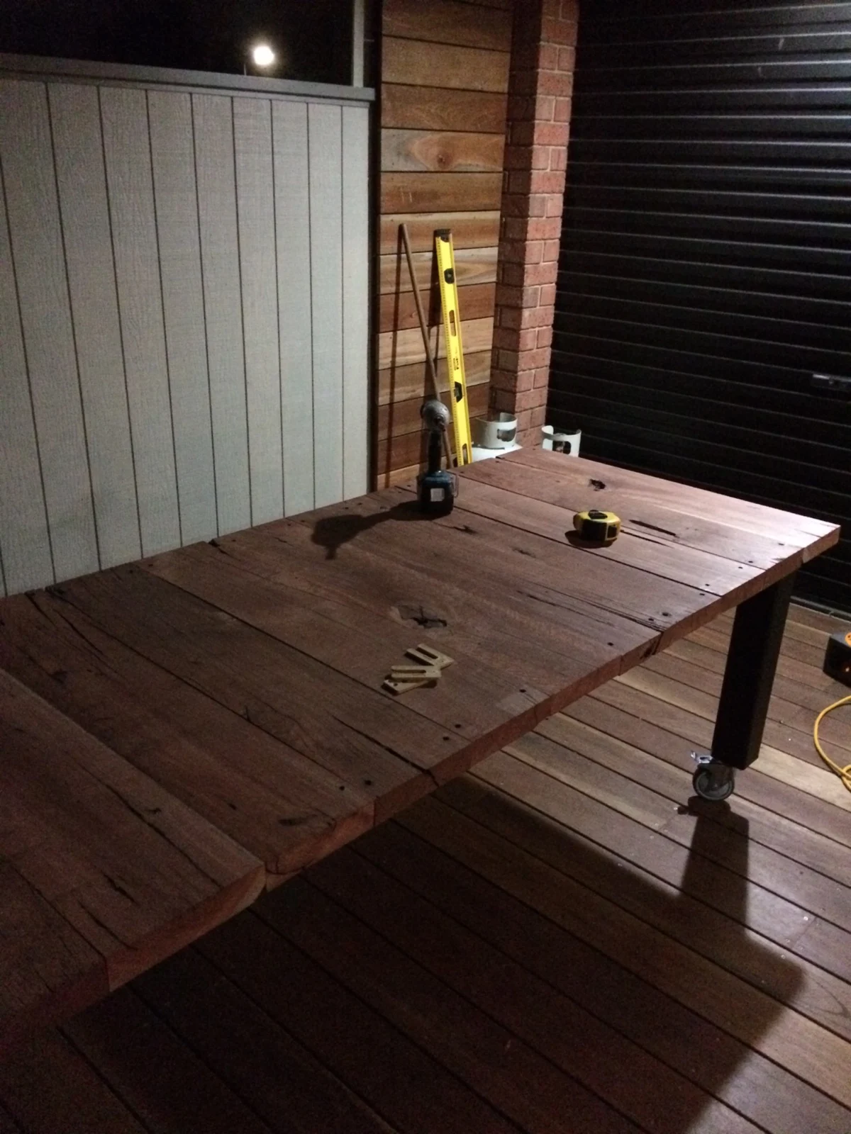 Timber dining table being assembled in the pergola