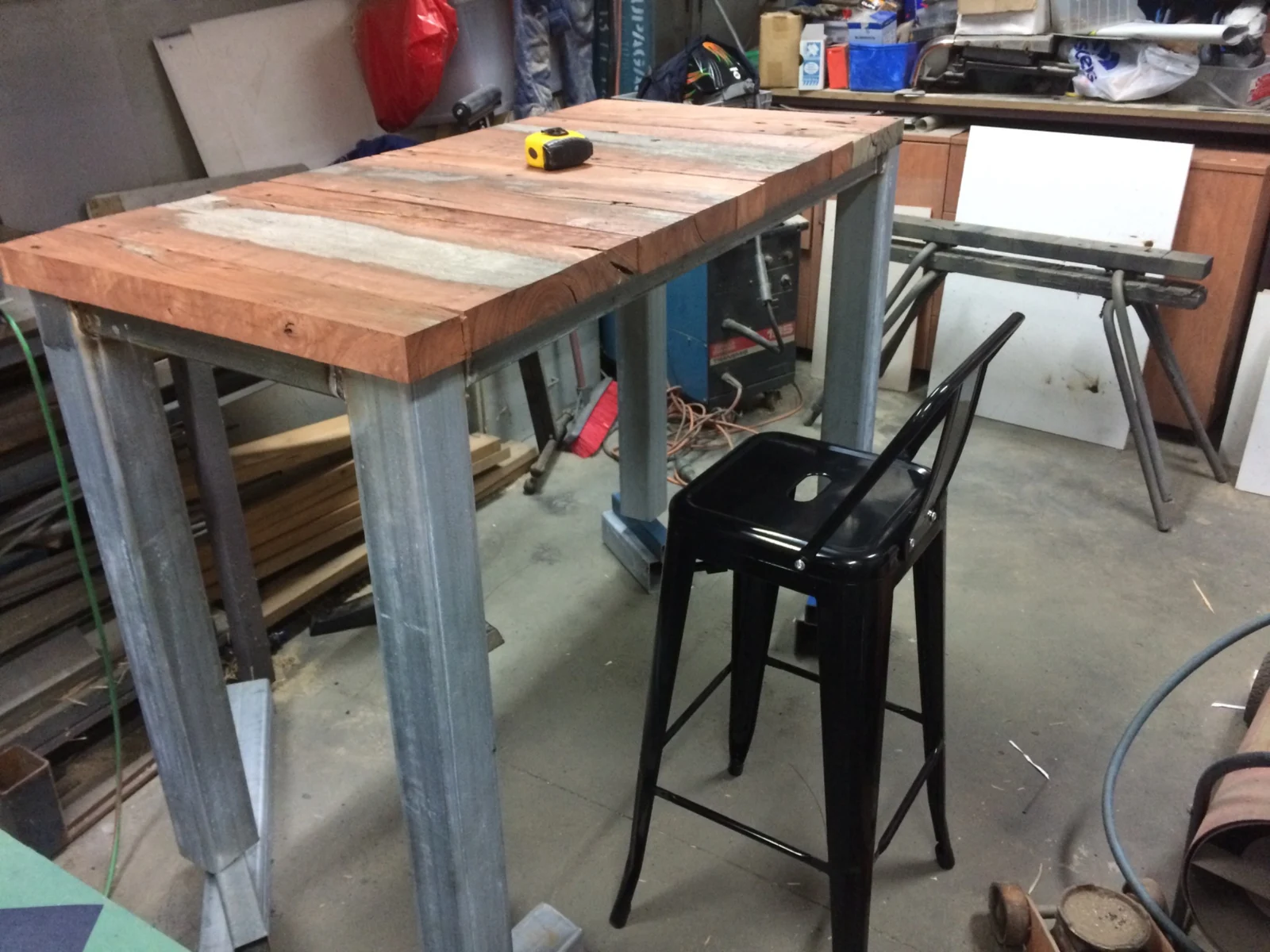 Timber-top bar table and steel frame being assembled in the workshop