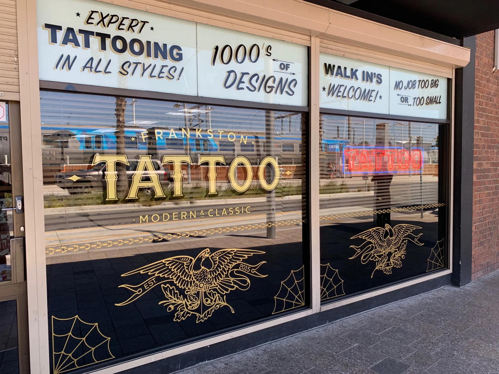 Tattoo studio shopfront with decorative gold window graphics by RADesignz